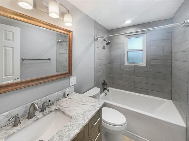 full bathroom with toilet, tiled shower / bath combo, and vanity