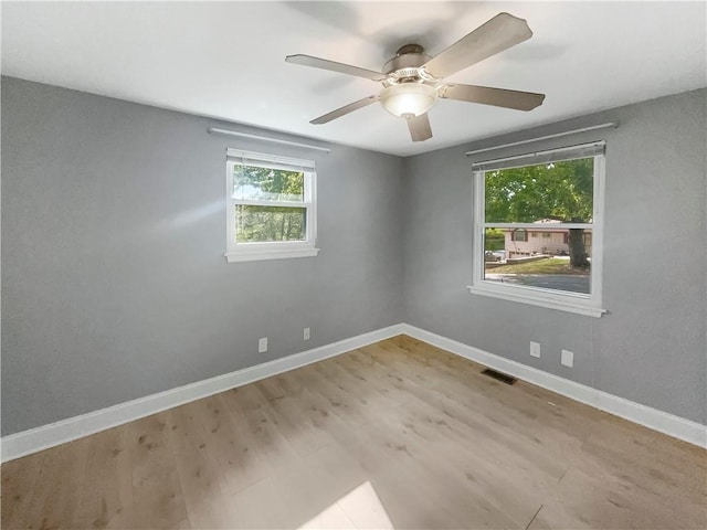 spare room with hardwood / wood-style floors and ceiling fan