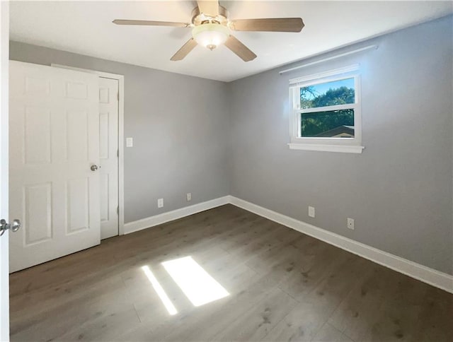 spare room with ceiling fan and dark hardwood / wood-style flooring