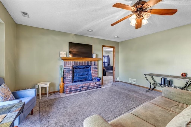 living room featuring light carpet, a brick fireplace, a textured ceiling, and ceiling fan