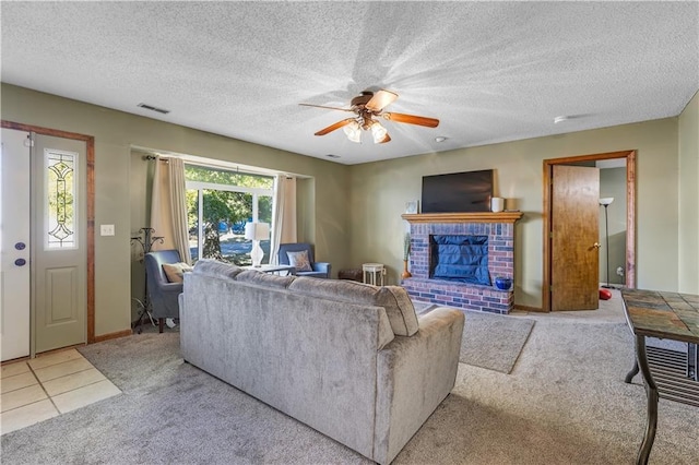 carpeted living room featuring ceiling fan, a textured ceiling, and a brick fireplace