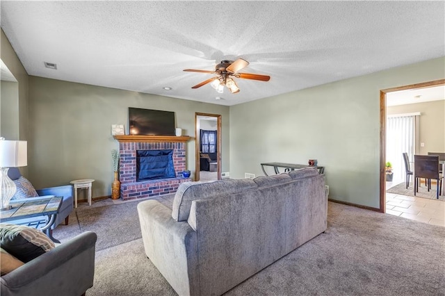 living room with light carpet, a textured ceiling, ceiling fan, and a brick fireplace