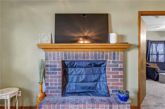 interior details featuring carpet and a brick fireplace