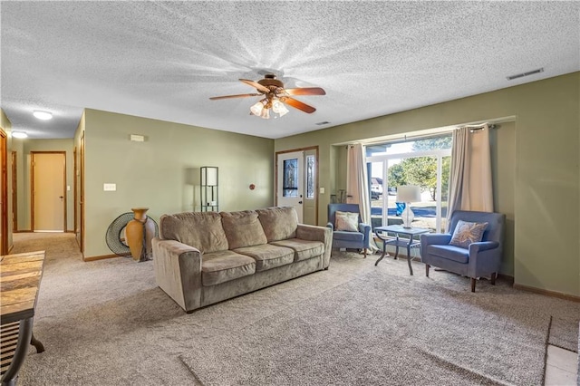 living room with a textured ceiling, light colored carpet, and ceiling fan