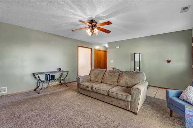 carpeted living room with ceiling fan and a textured ceiling