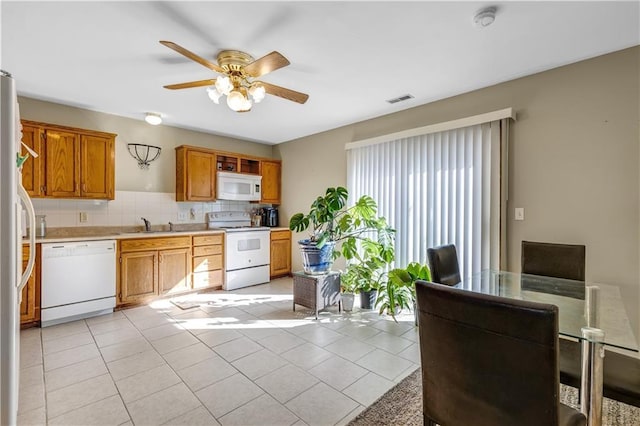 kitchen featuring white appliances, ceiling fan, tasteful backsplash, and light tile patterned floors