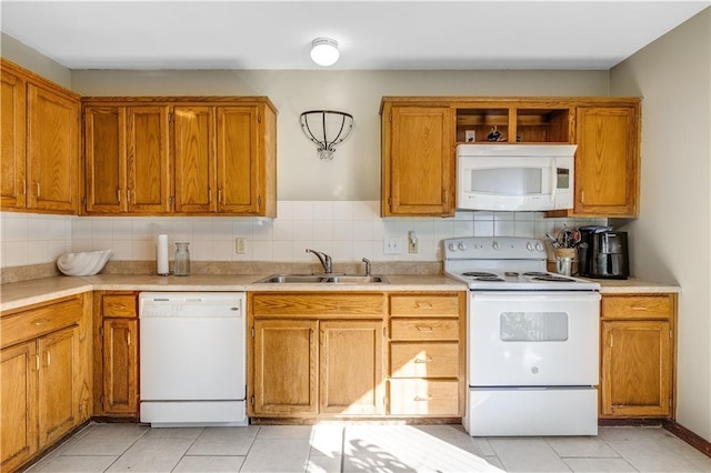 kitchen with white appliances, light tile patterned flooring, decorative backsplash, and sink