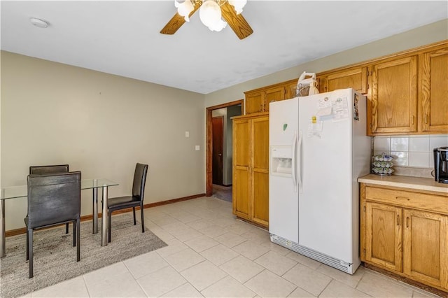 kitchen featuring light tile patterned flooring, ceiling fan, tasteful backsplash, and white fridge with ice dispenser