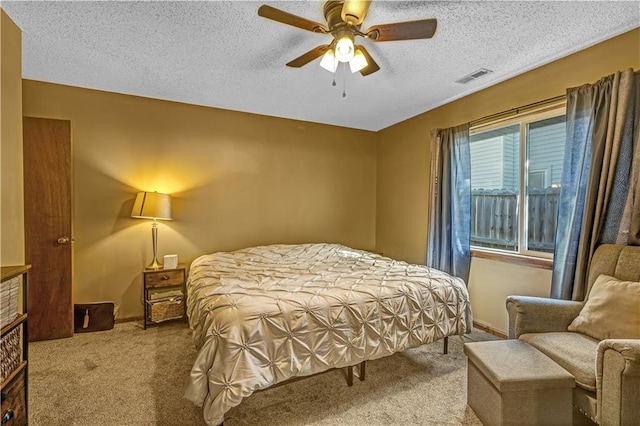 bedroom featuring ceiling fan, a textured ceiling, and carpet floors