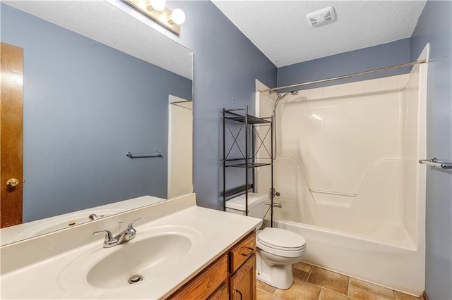 full bathroom featuring toilet, a textured ceiling, vanity, and tub / shower combination