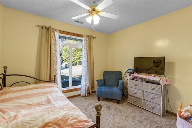 bedroom with light carpet, a textured ceiling, and ceiling fan