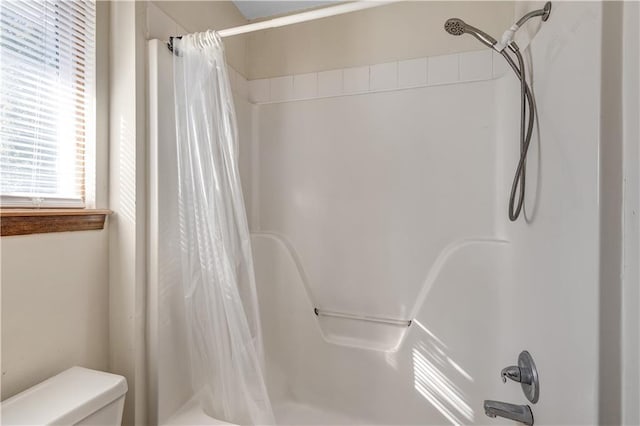 bathroom featuring toilet and shower / bath combo with shower curtain