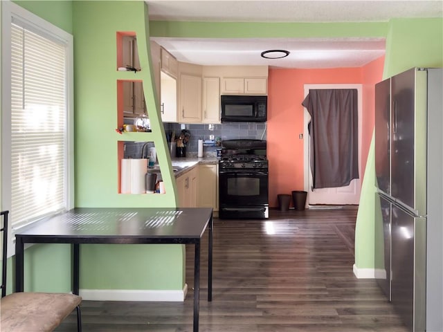 kitchen featuring dark hardwood / wood-style flooring, black appliances, and backsplash