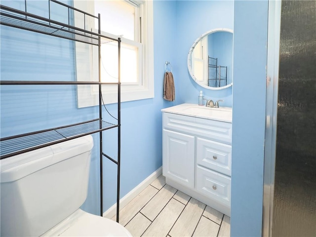 bathroom with vanity, toilet, and wood-type flooring