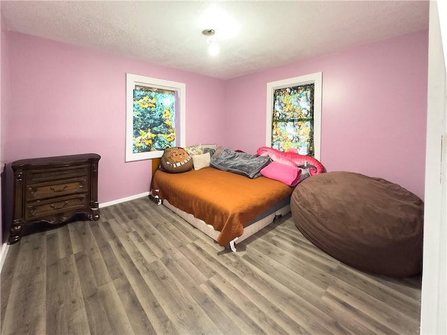 bedroom with a textured ceiling and hardwood / wood-style floors