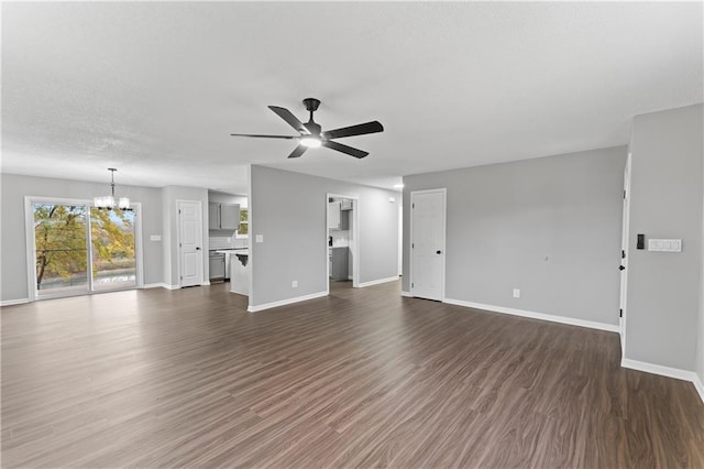 unfurnished living room with dark wood-type flooring and ceiling fan with notable chandelier