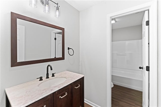 full bathroom with vanity, toilet, hardwood / wood-style flooring, and bathing tub / shower combination