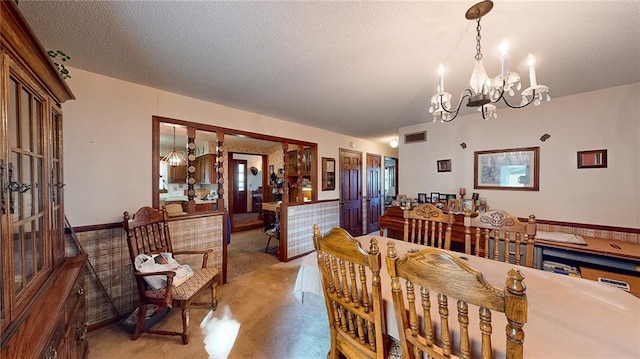 dining space with a chandelier and a textured ceiling