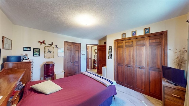 carpeted bedroom with a closet and a textured ceiling