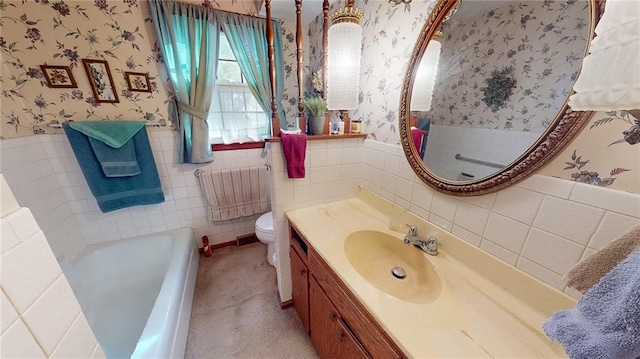 bathroom featuring tile walls, vanity, toilet, and a bathing tub