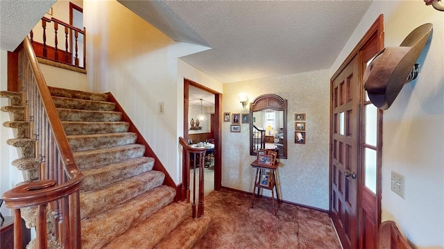 carpeted entryway featuring a textured ceiling