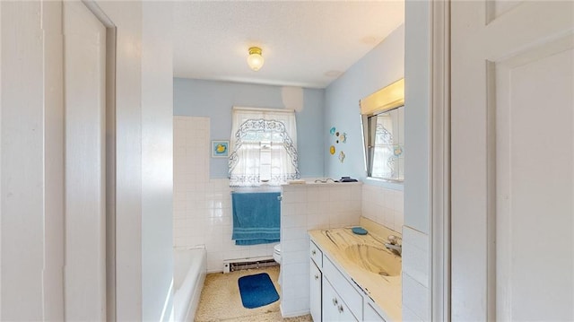 bathroom with a tub to relax in, toilet, a baseboard radiator, vanity, and tile walls