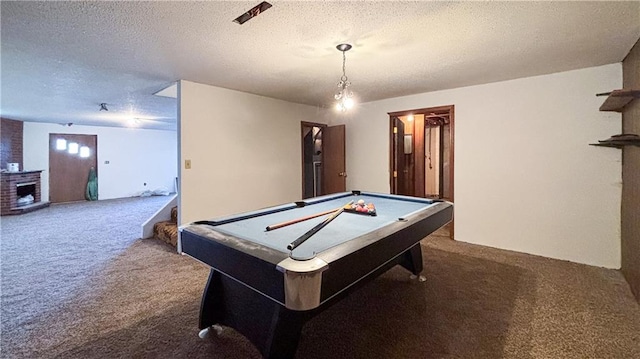 rec room featuring a textured ceiling, carpet flooring, billiards, and a brick fireplace