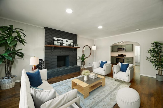 living room featuring crown molding, a fireplace, and dark hardwood / wood-style floors