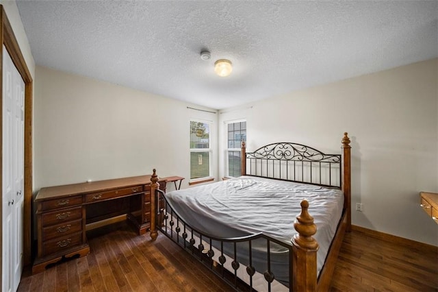 bedroom featuring dark wood-type flooring, a textured ceiling, and a closet