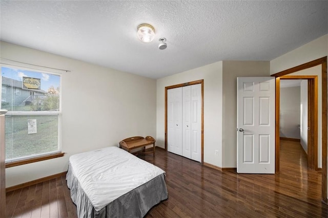 bedroom featuring a textured ceiling, dark hardwood / wood-style floors, and a closet