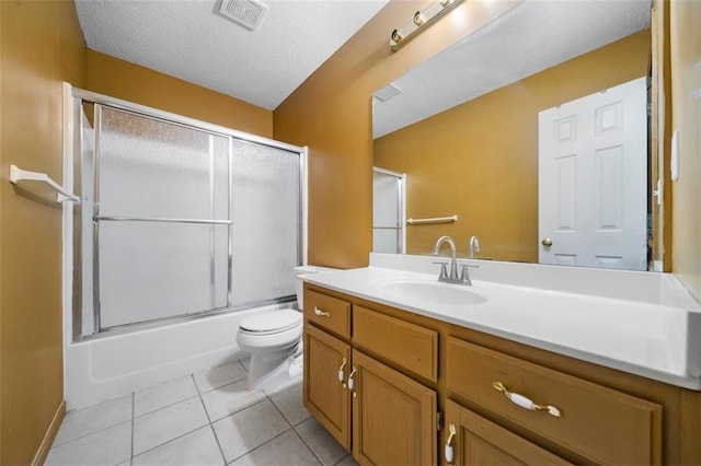 full bathroom with a textured ceiling, toilet, enclosed tub / shower combo, tile patterned floors, and vanity