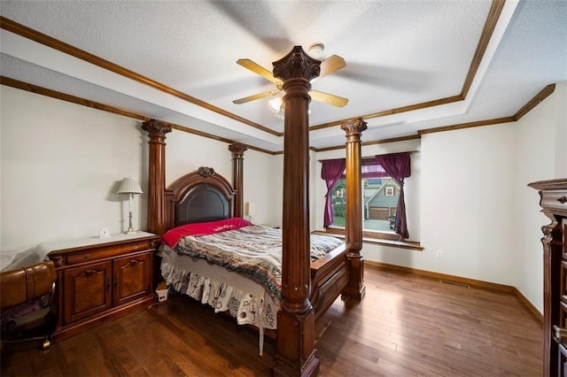 1116 N Mohican Ct, Independence, MO 64056 - bedroom featuring dark wood-style floors, a textured ceiling, baseboards, crown molding, and a tray ceiling