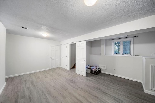 basement featuring hardwood / wood-style floors and a textured ceiling