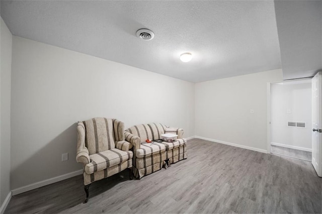 living area featuring a textured ceiling and wood-type flooring