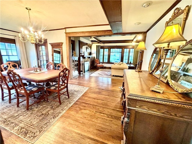 421 W Thompson St, Maryville, MO 64468 - dining space featuring wood finished floors, a chandelier, plenty of natural light, and crown molding