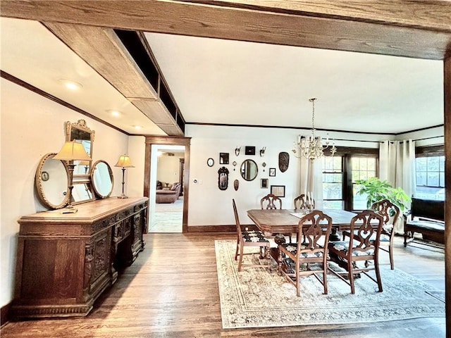 421 W Thompson St, Maryville, MO 64468 - dining area featuring wood finished floors, crown molding, a notable chandelier, and baseboards