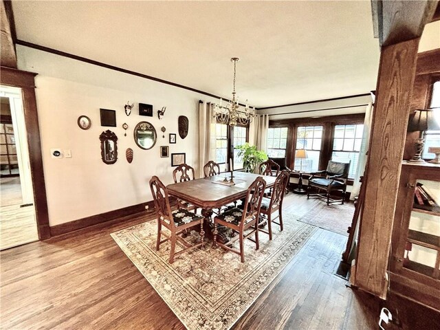 421 W Thompson St, Maryville, MO 64468 - dining room with baseboards, wood finished floors, an inviting chandelier, and crown molding