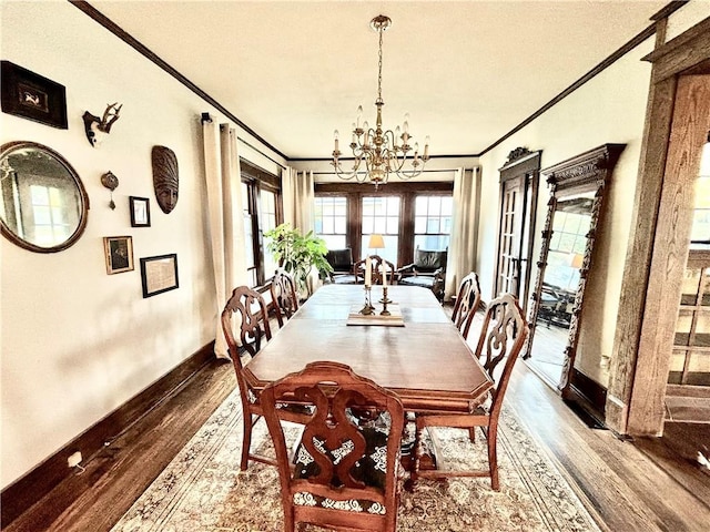 421 W Thompson St, Maryville, MO 64468 - dining area featuring french doors, baseboards, an inviting chandelier, ornamental molding, and wood finished floors