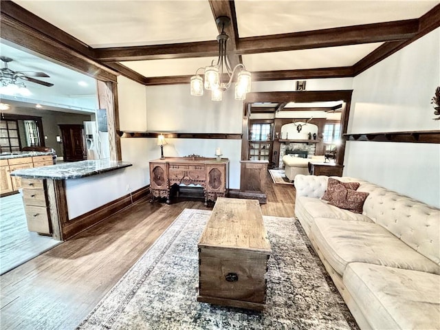421 W Thompson St, Maryville, MO 64468 - living room with beamed ceiling, baseboards, wood finished floors, and ceiling fan with notable chandelier