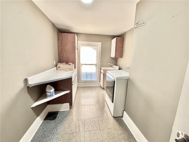 421 W Thompson St, Maryville, MO 64468 - clothes washing area featuring a sink, washing machine and clothes dryer, cabinet space, and baseboards