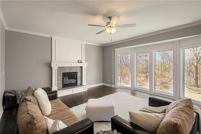 living room featuring ornamental molding, ceiling fan, a tile fireplace, and dark hardwood / wood-style flooring