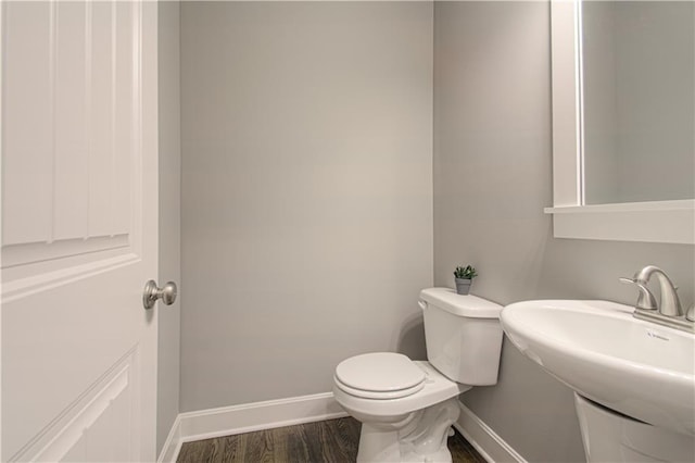 bathroom featuring toilet, wood-type flooring, and sink