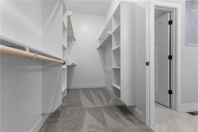 spacious closet featuring light colored carpet