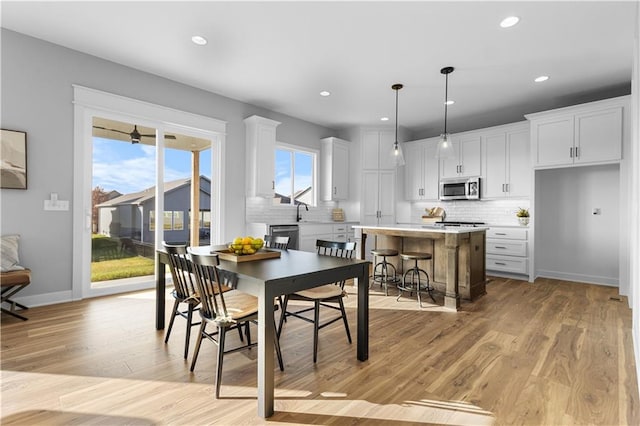 dining space with sink and light hardwood / wood-style flooring