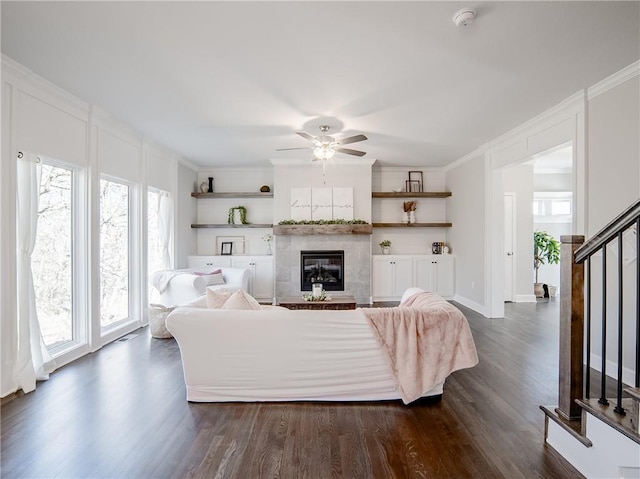 living room with dark wood-type flooring, crown molding, and a tile fireplace