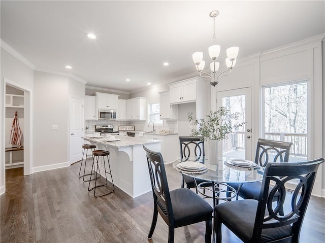 dining room with crown molding, a notable chandelier, dark wood-style floors, and recessed lighting