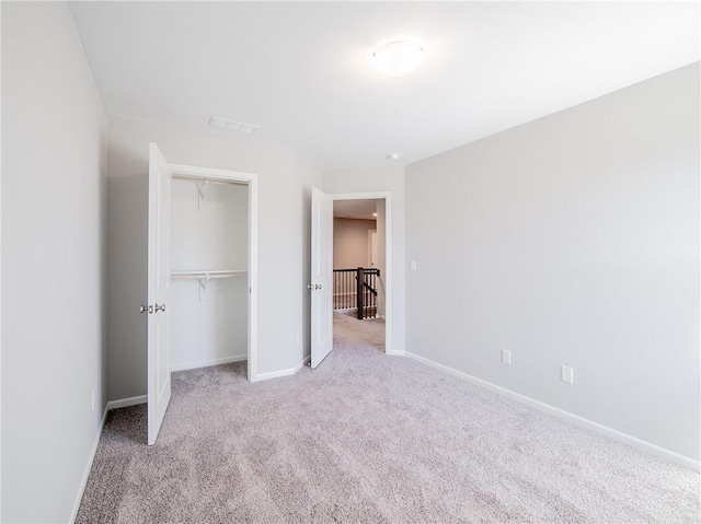 unfurnished bedroom with a closet, baseboards, and carpet