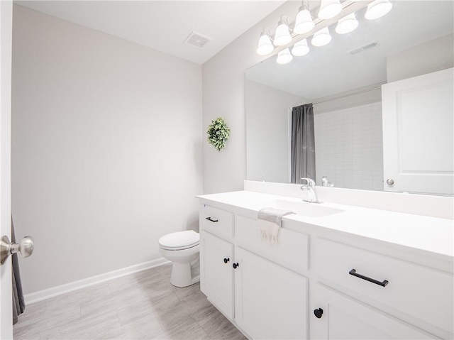 bathroom with visible vents, toilet, vanity, and baseboards