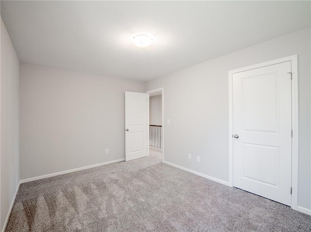 carpeted empty room featuring baseboards