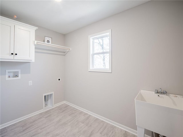 washroom featuring baseboards, hookup for a washing machine, cabinet space, hookup for an electric dryer, and a sink